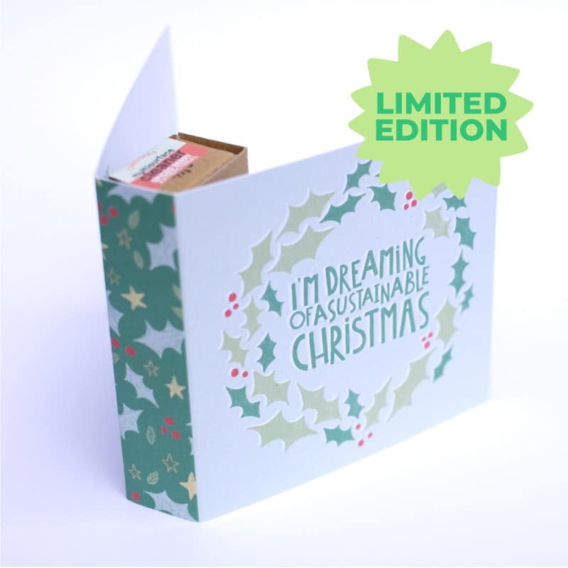 Christmas Card which says 'I'm dreaming of a sustainable Christmas' on the front. The design is surrounded by a wreath of holly leaves. The card contains a water soluble surface cleaner refill.